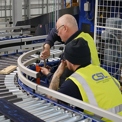 CSL Engineers repairing damaged lineshaft conveyor in warehouse