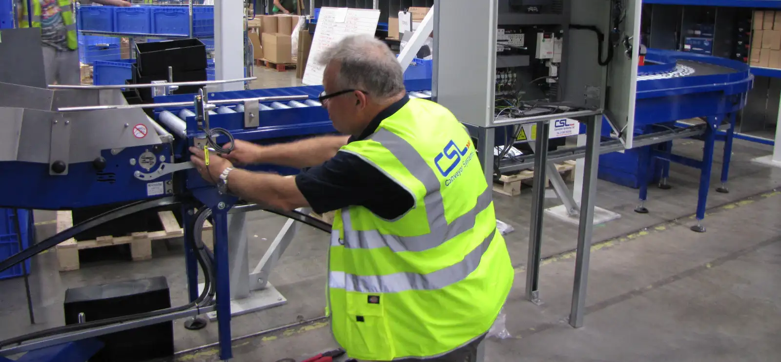 CSL engineer repairing roller conveyor in factory