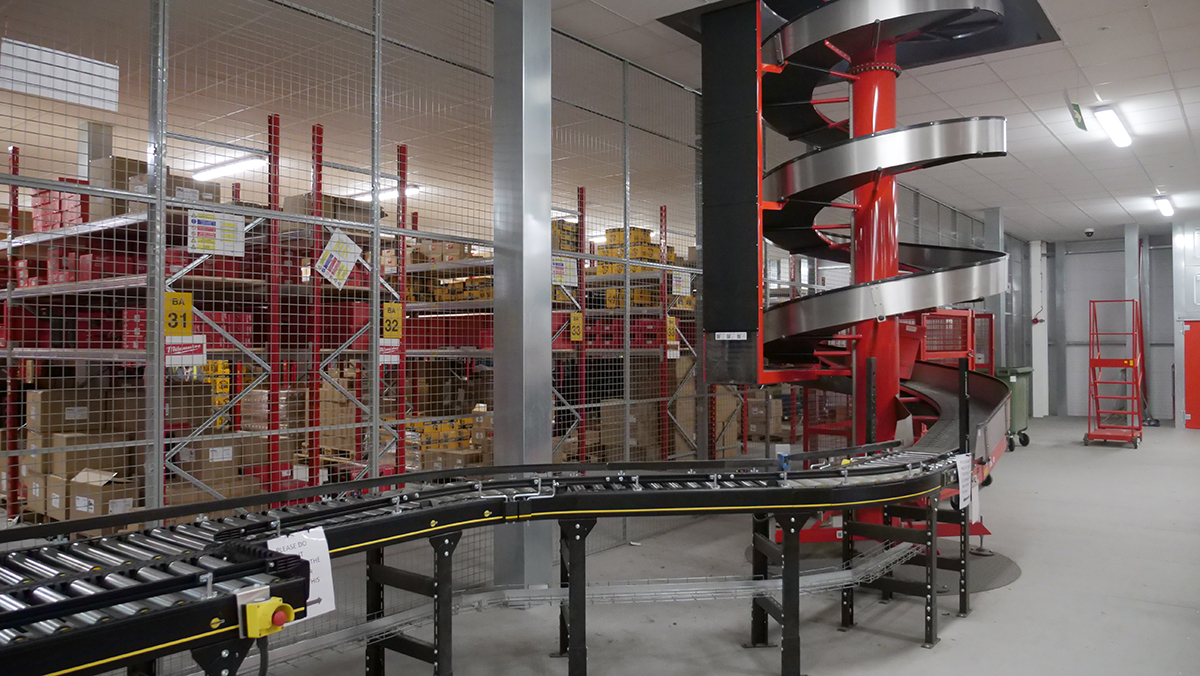 Spiral elevator feeding onto Interroll motorised roller conveyor in fulfilment centre