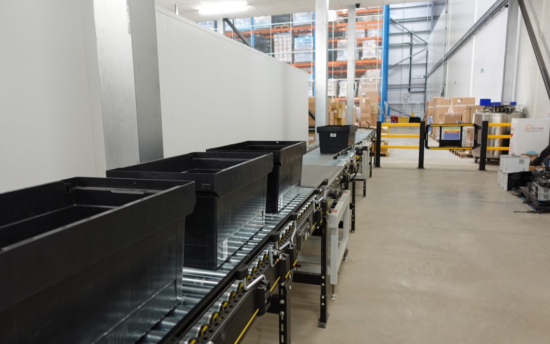 Interroll roller conveyor with totes accumulating